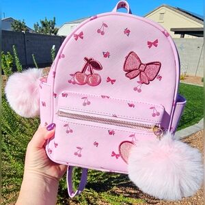 Pink mini backpack with a cherry and bow pattern